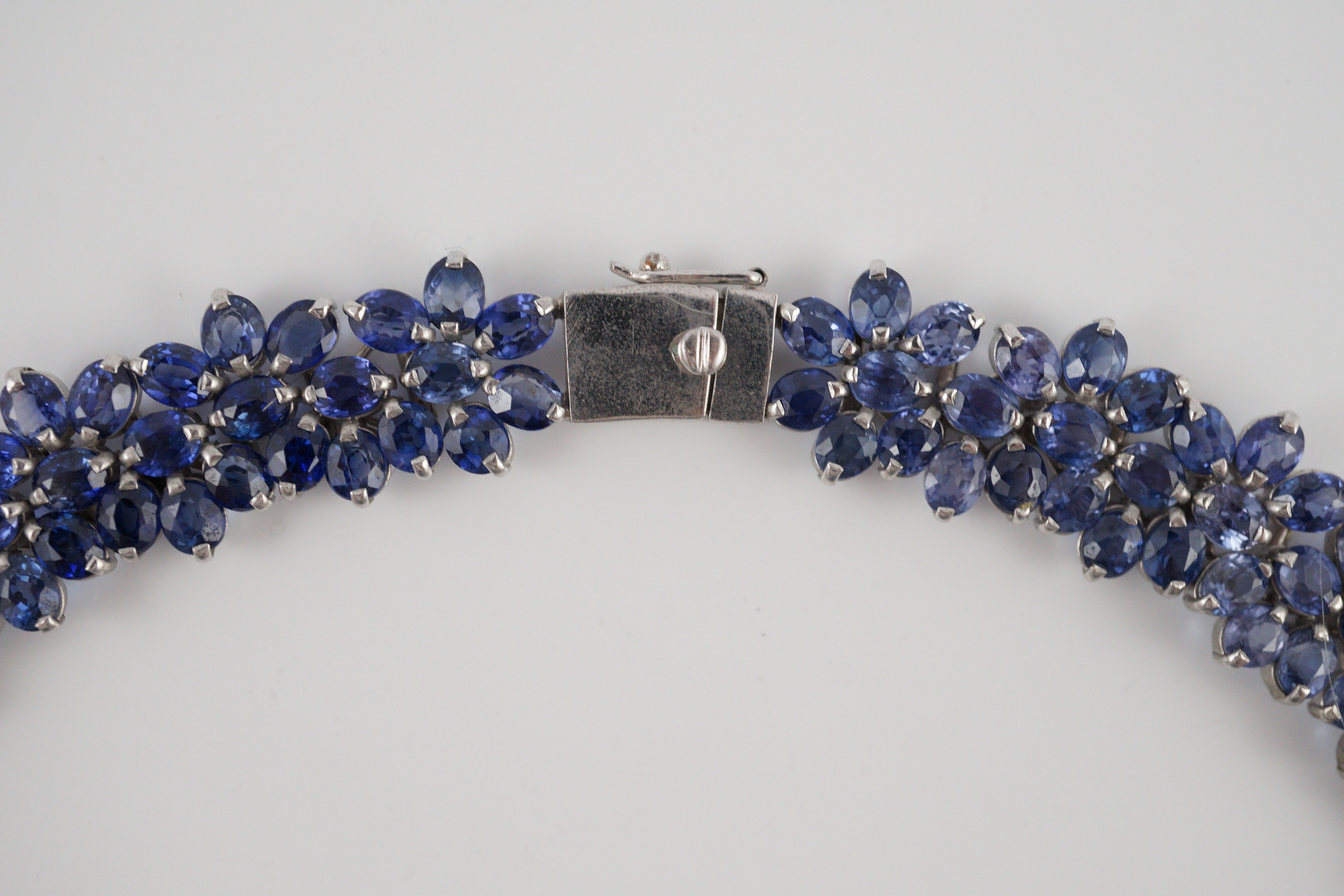 An 18K white gold and synthetic sapphire? flower head cluster set necklace